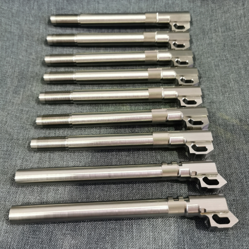 9 finished stainless steel pistol barrels laid out vertically